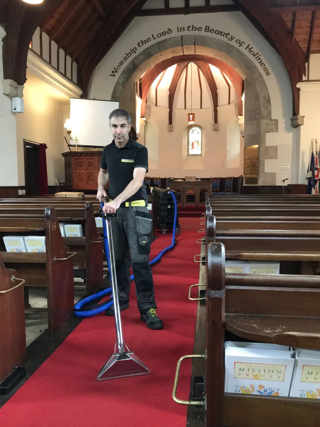 Städare dammsuger mattan i en kyrka