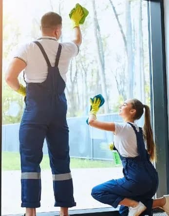 Städteam putsar fönster i ett ljust rum