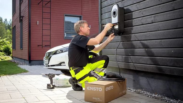 Elektriker installerar en laddbox för elbil på husfasaden