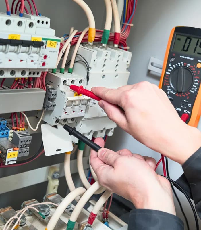 Elektriker mäter spänning i en elcentral