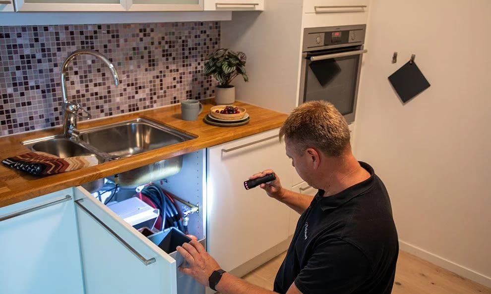 Elektriker monterar belysning i ett köksskåp