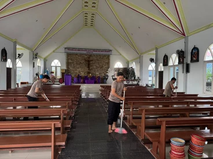 Städpersonal rengör kyrkbänkar och golv i en kyrka