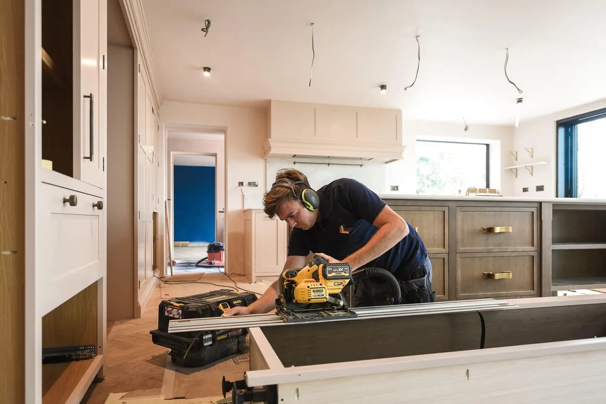 Snickare sågar med cirkelsåg vid köksinredning under renovering